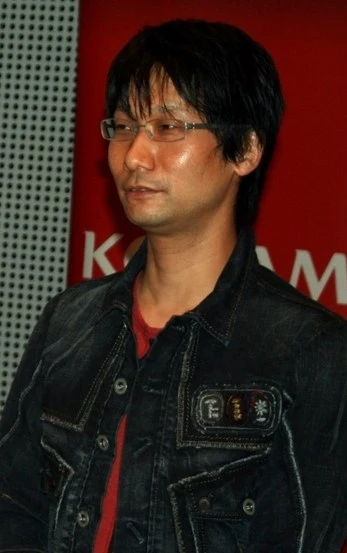Hideo Kojima w 2007 roku na tle czerwonego logo Konami