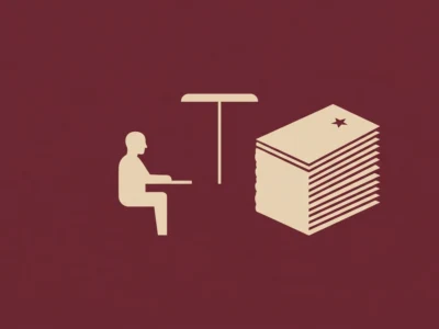 Silhouette of a person sitting at a desk facing a tall stack of papers or files on the right.
