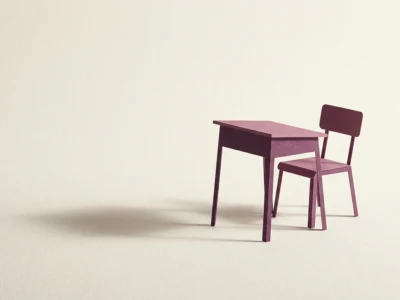 Purple miniature desk with a matching chair on a pale beige background.