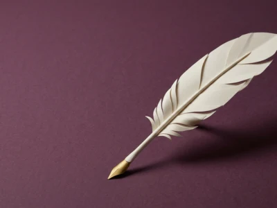 White paper quill pen with a gold nib resting on a burgundy background.