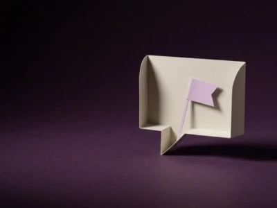 Beige paper speech bubble with a small pink flag sticky note on a dark purple background.