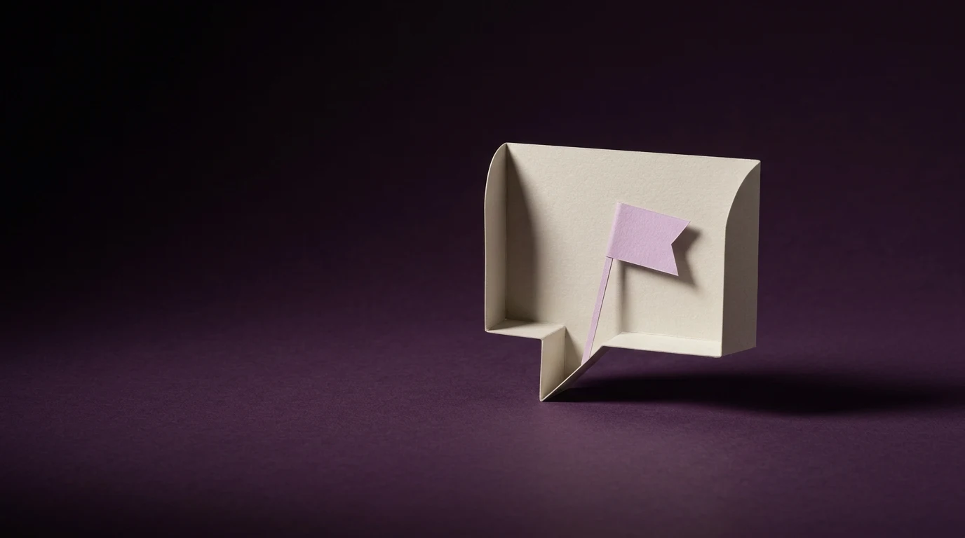 Jak zgłosić deepfake na Facebooku i Instagramie krok po kroku - Promptowy Beige paper speech bubble with a small pink flag sticky note on a dark purple background.