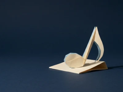 Beige origami sculpture of a musical note on a folded base against a dark blue background.