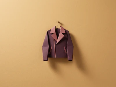 Origami leather-brown jacket hanging on a hook against a warm, tan wall.