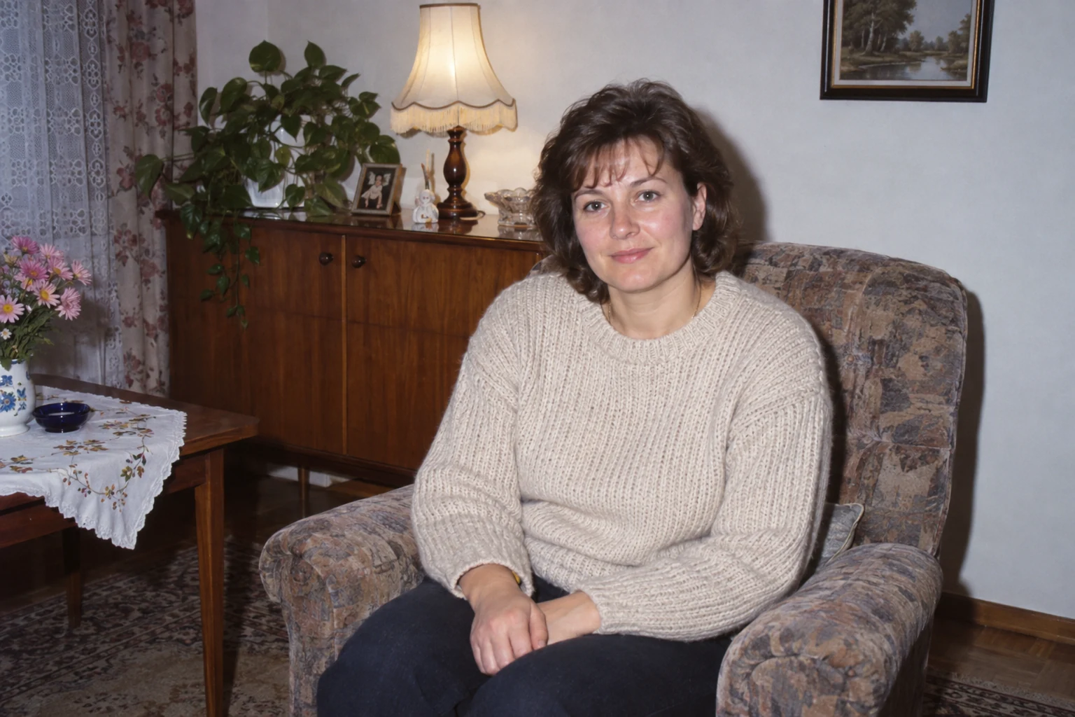 Kobieta w jasnym swetrze w fotelu oświetlona bezpośrednim fleszem w niewielkim pokoju - Promptowy Kobieta w jasnym swetrze w fotelu, oświetlona bezpośrednim fleszem w niewielkim pokoju