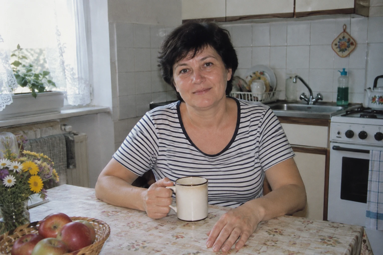 Kobieta przy stole z kubkiem z twarzą i obiema dłońmi widocznymi w kadrze - Promptowy Kobieta przy stole z kubkiem, z twarzą i obiema dłońmi widocznymi w kadrze