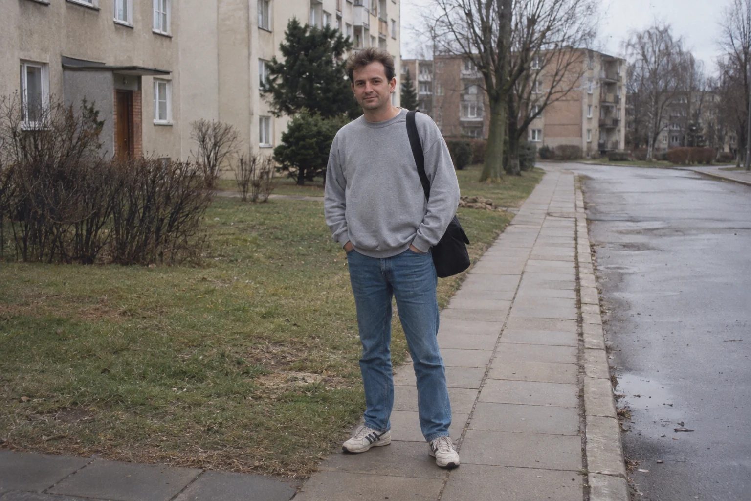Mężczyzna z płócienną torbą na osiedlowym chodniku w pochmurny dzień - Promptowy Mężczyzna z płócienną torbą na osiedlowym chodniku w pochmurny dzień