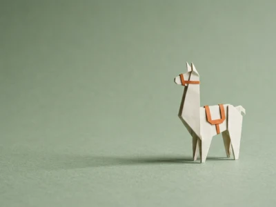 Mark Zuckerberg i AI po co Meta rozdaje modele Llama za darmo - Promptowy Origami white llama with orange saddle and bridle on a green backdrop.