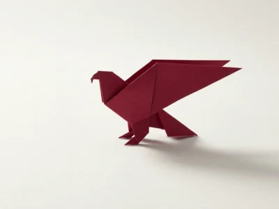Polskie AI modele uczone po polsku Polacy w globalnych laboratoriach i czego nam brakuje - Promptowy Red origami bird standing on a white surface with a soft shadow behind it