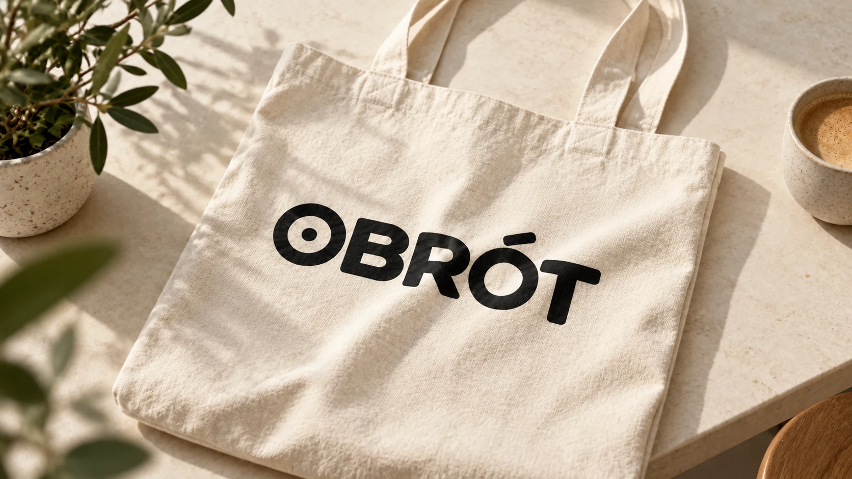 Czarny logotyp OBRÓT na naturalnej bawełnianej torbie.