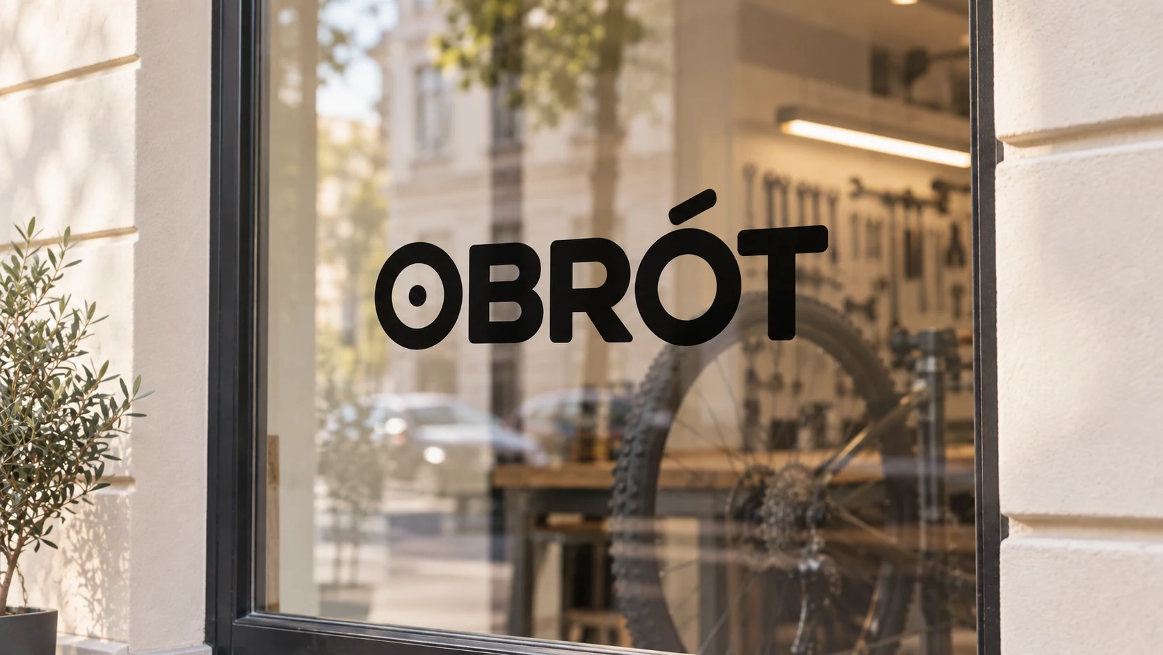 Logotyp OBRÓT na szybie serwisu rowerowego.