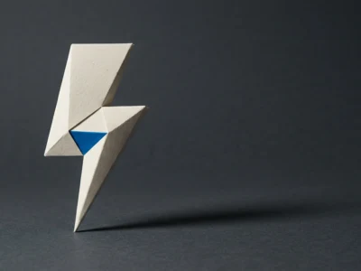 Abstract geometric origami sculpture in white paper with a blue inner triangle on a dark surface.