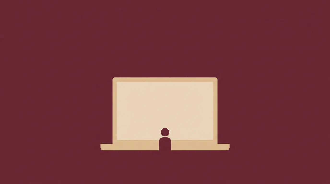 Silhouette of a person sitting in front of an open laptop on a maroon background.