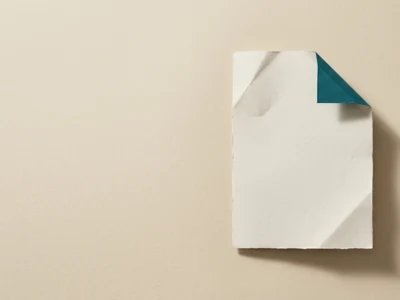 Zdjęcie do CV z AI gotowe polecenie i zasady których nie warto łamać - Promptowy White square sheet of paper with a teal folded corner on a beige background.