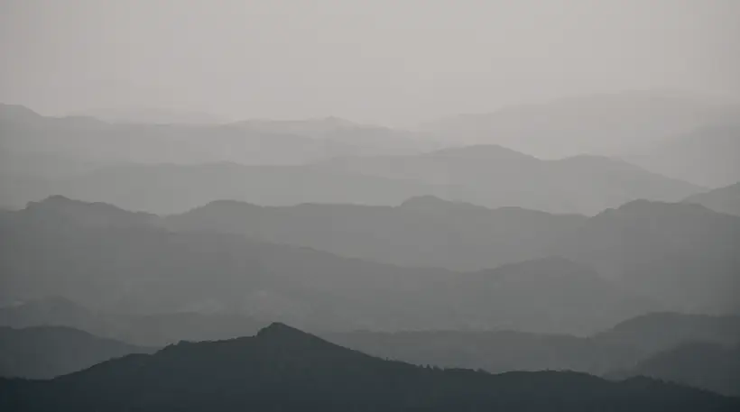 Tatry we mgle jesienią: warstwy grzbietów rozmywające się w szarość, stonowana paleta.